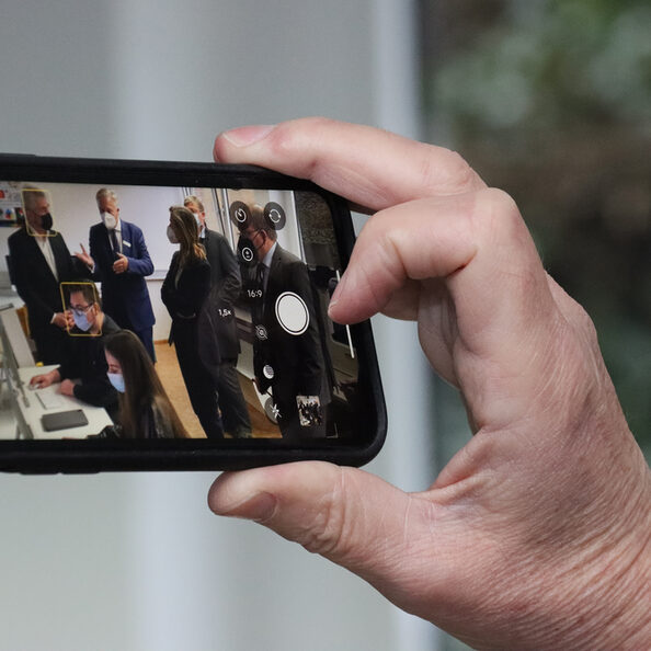 Eine Hand hält ein Handy hoch.