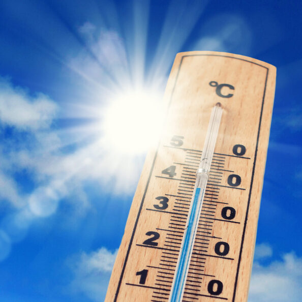 Thermometer vor blauem Himmel.